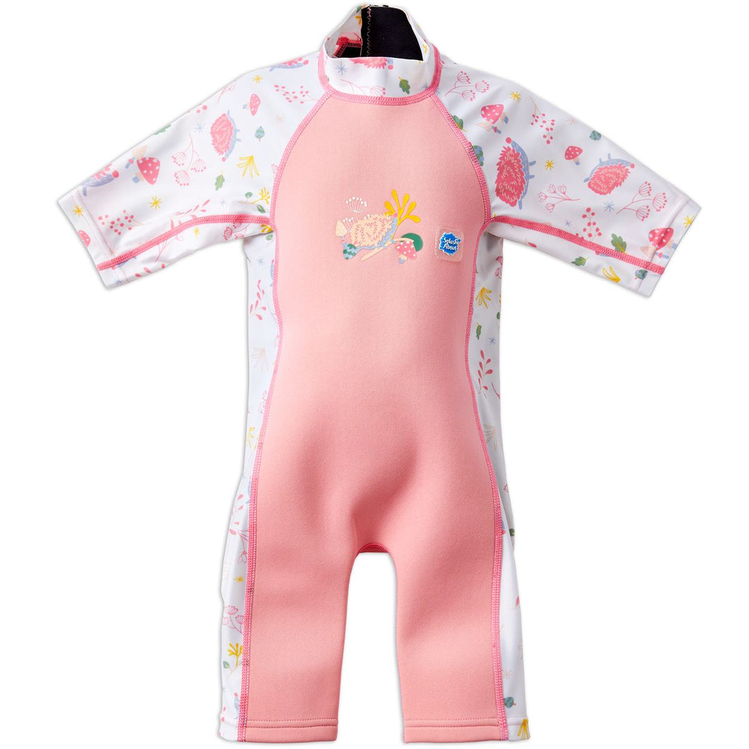 One piece UV sun and sea wetsuit for toddlers in pink. Forest themed print including hedgehogs, mushrooms and leaves on sleeves, side panels, neck and chest. Front.