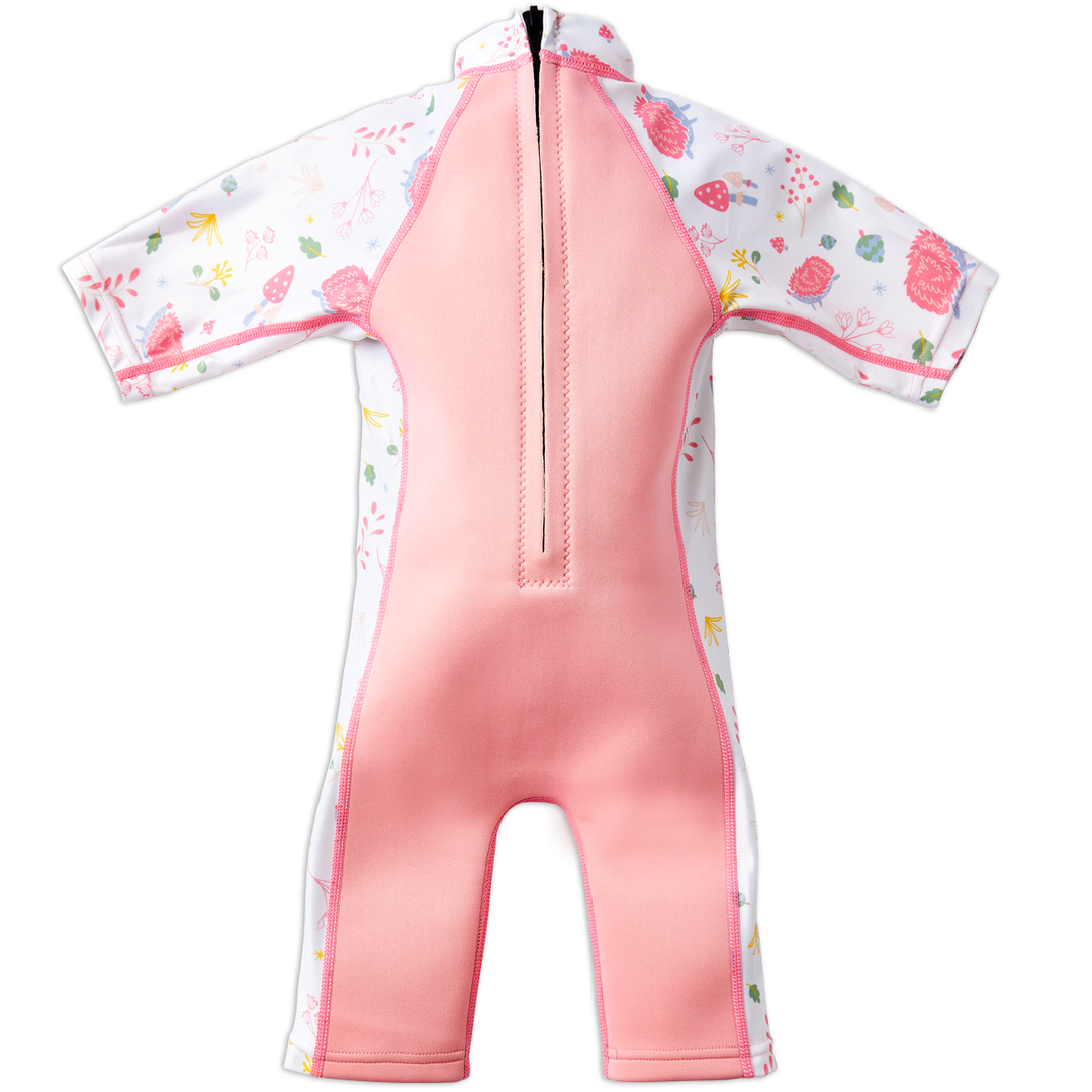 One piece UV sun and sea wetsuit for toddlers in pink. Forest themed print including hedgehogs, mushrooms and leaves on sleeves, side panels and neck. Pink panel at the back, including zip.