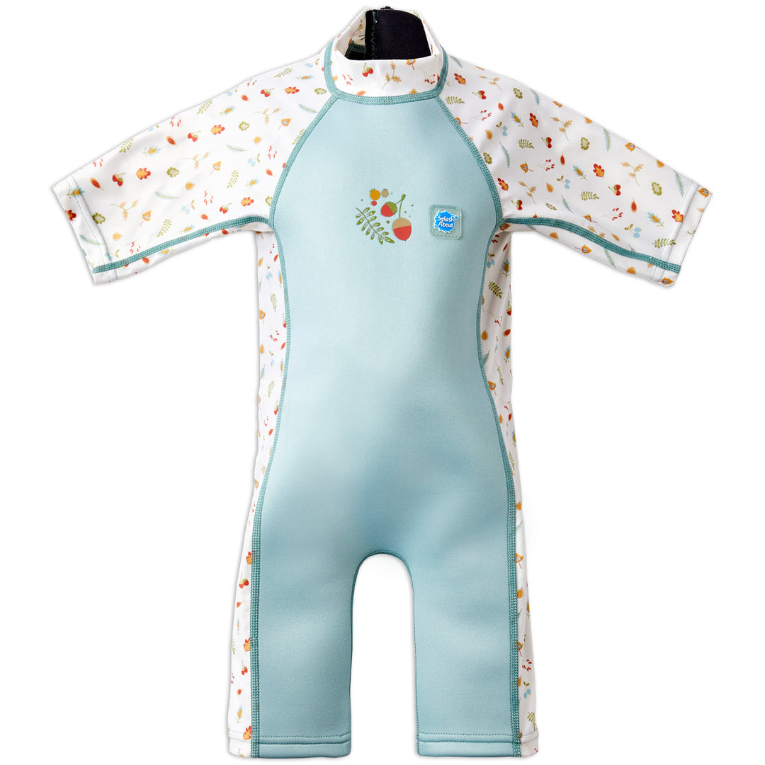One piece UV sun and sea wetsuit for toddlers in white and light blue. Acorns and leaves themed print on sleeves, side panels, neck and chest. Front.