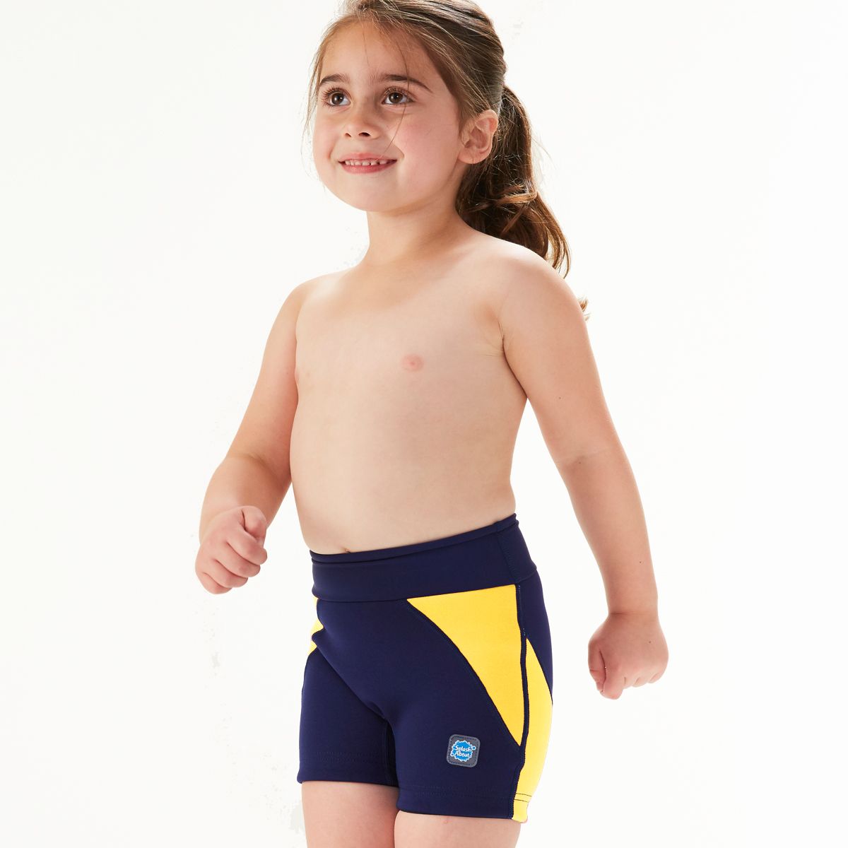 Lifestyle image of child wearing neoprene swim shorts in navy blue with yellow trims. Front.
