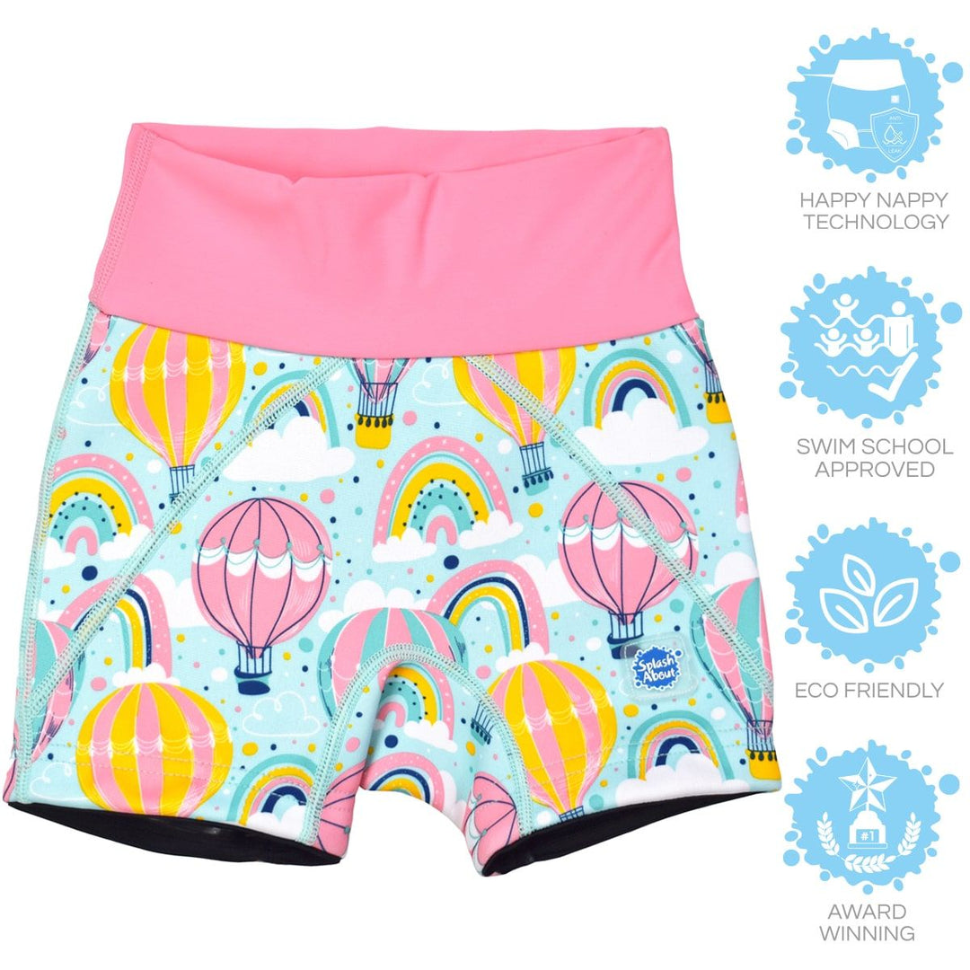 Lifestyle image of child wearing neoprene swim shorts in baby blue with pink waist and hot air balloons themed print, including clouds and rainbows. 