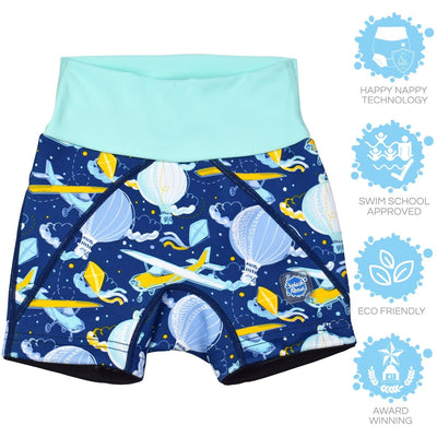 Lifestyle image of toddler wearing neoprene swim shorts in navy blue with light green waist and hot air balloons themed print, including airplanes, kites and clouds.