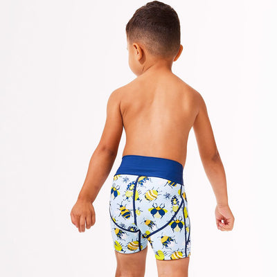 Lifestyle image of toddler wearing neoprene swim shorts in light blue with navy blue trims and insects print. Back.